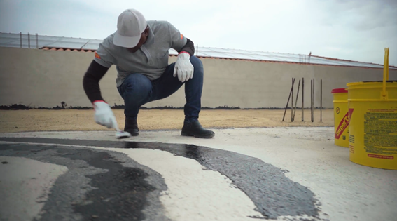 Aplicação de impermeabilizante ImperTop em laje — profissional aplicando com pincel